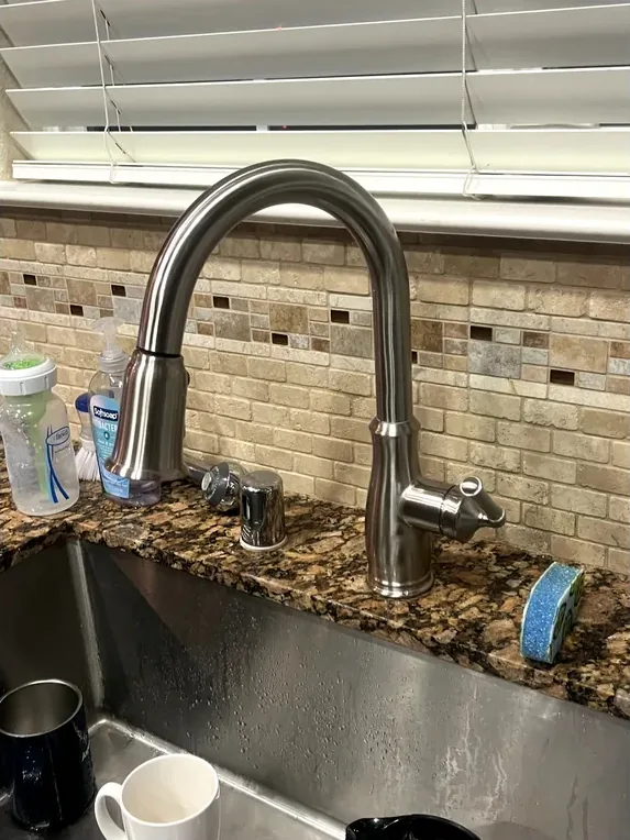 A new, modern kitchen faucet professionally installed.